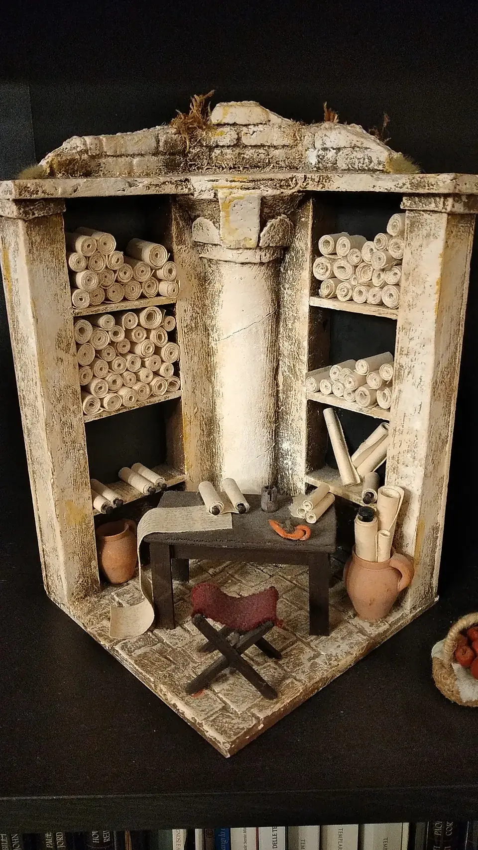 Diorama in miniatura di una bottega d'epoca romana con colonne, banco da lavoro e attrezzi